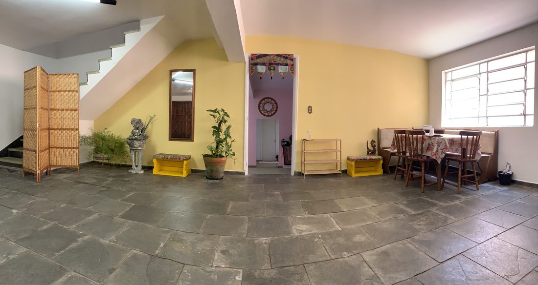 Hall de entrada da Casa Sananda, com piso de pedra e altar
